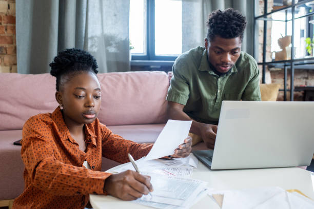 istock Two young African colleagues working with financial papers and computer data 1364117441