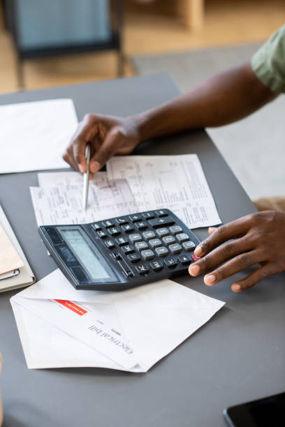 istock Hands of African man checking data in unpaid bills and tax payment forms 1364117445