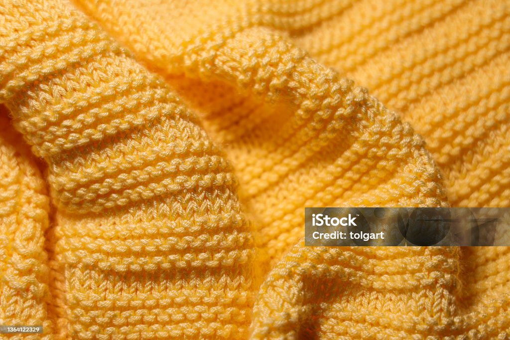 Wavy yellow woolen fabric background Warm knitted sweater close up Sweater Stock Photo