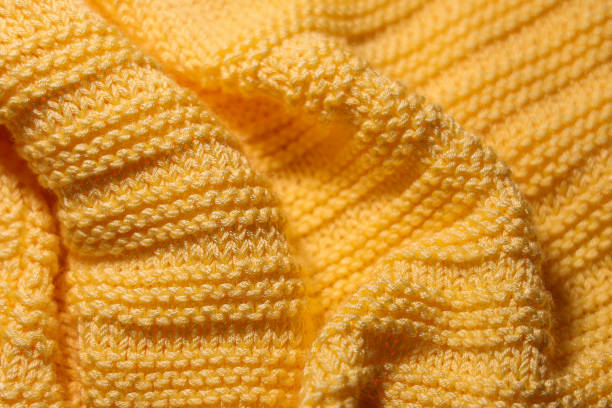 Wavy yellow woolen fabric background Warm knitted sweater close up Crochet stock pictures, royalty-free photos & images