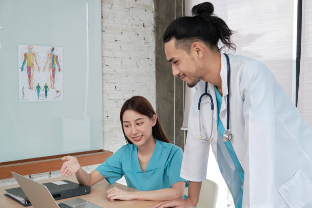 istock Two uniformed young doctors work in medical clinic office. 1364123922