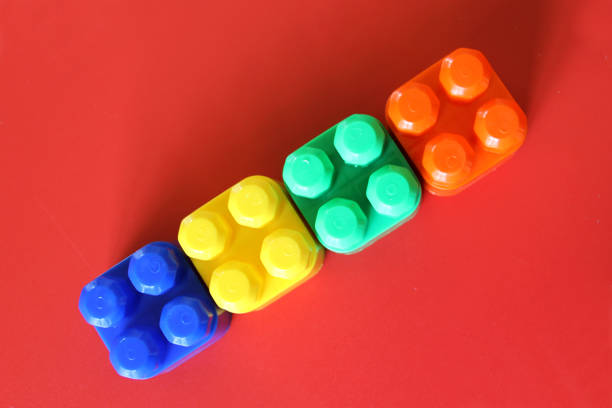 istock Buildable colored plastic blocks to play, build and organize on a red background as a concept of inclusion, diversity and plurality 1364126045