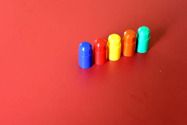 Buildable colored plastic blocks to play, build and organize on a red background as a concept of inclusion