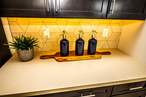 Three Seltzer Bottles And Wood Cutting Board As Decor On Kitchen Counter