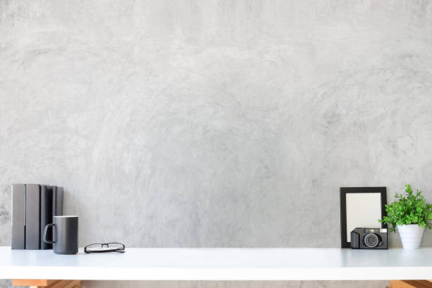 istock Creative designer workspace with photo frame, camera, coffee cup and houseplant on white table. 1364130147