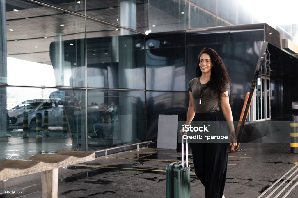 Distracted, a Brazilian mulger looks ahead while holding her suitcase 30-34 Years Stock Photo