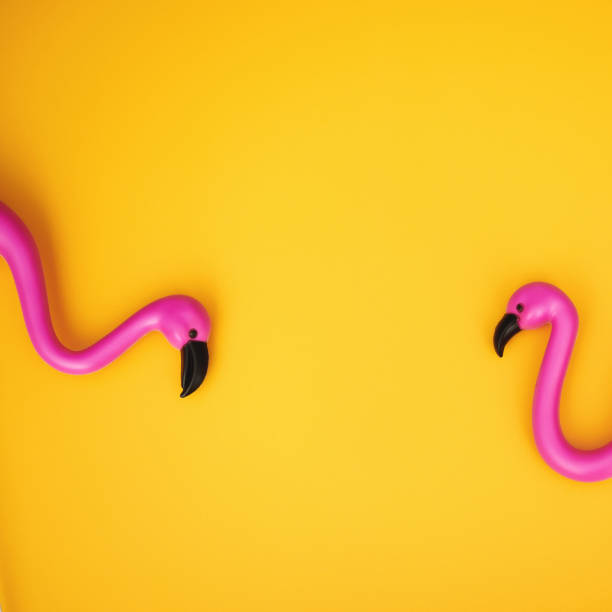 istock Plastic flamingo couple on a vibrant yellow background with space for copy 1364131916