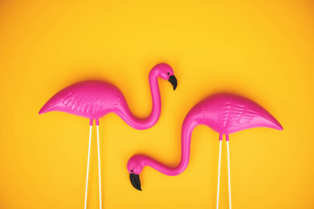 couple de flamants roses en plastique sur un fond jaune vif avec espace pour la copie - plastic flamingo photos et images de collection