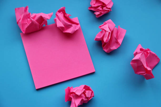 Adhesive note and paper balls on blue background