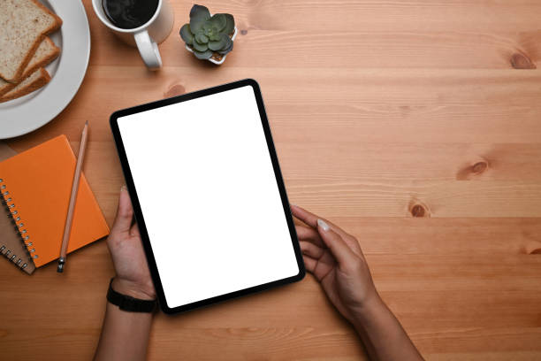 istock Above view young woman holding digital tablet with white screen. 1364134867
