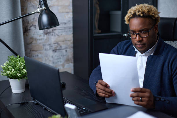 istock African-American businessman carefully examines the accounting documents 1364135501