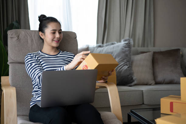 istock Smiling young woman unpack cardboard parcel box at home. 1364135552