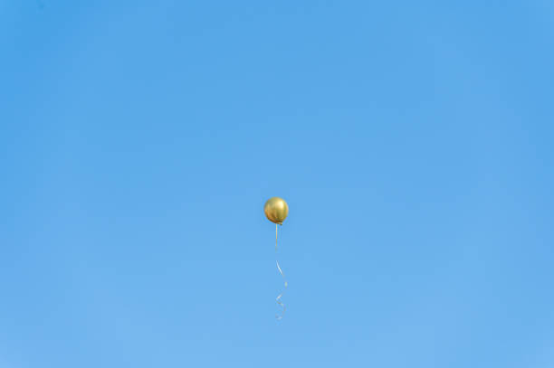 un ballon doré volait sous le ciel bleu et les nuages blancs - bouee de haut chine photos et images de collection