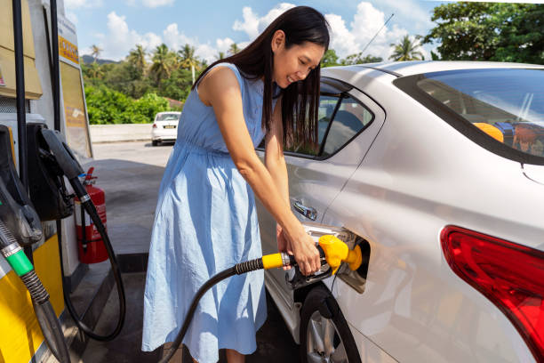 Woman refueling her car at a petrol station stock photo