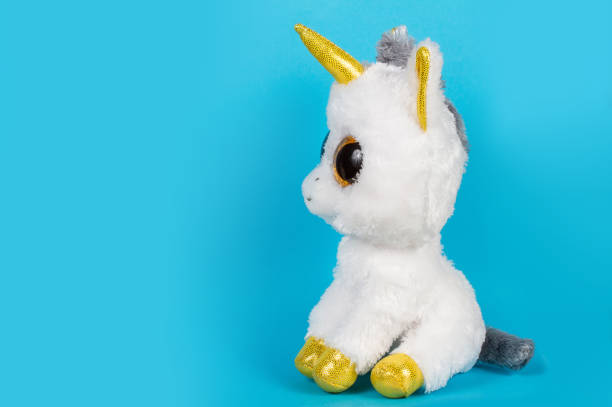 istock A white toy unicorn sits sideways on a blue background. 1364144487
