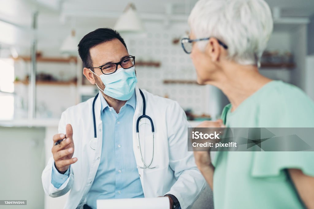 Doctor consulting a senior patient Doctor visiting a senior woman at home Doctor Stock Photo