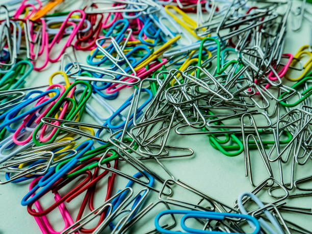 istock a mixture of color and silver paper clips on a white base 1364144568