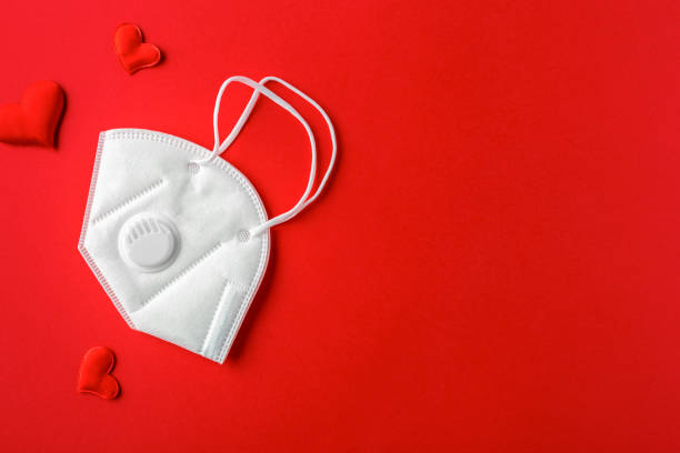 istock Composition with red hearts and mask for Valentine's Day on red background. Flat lay. Love and relationships concept. 1364145587