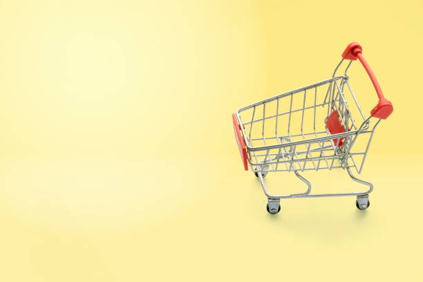 istock shopping trolley on yellow background with some copy space. 1364146392
