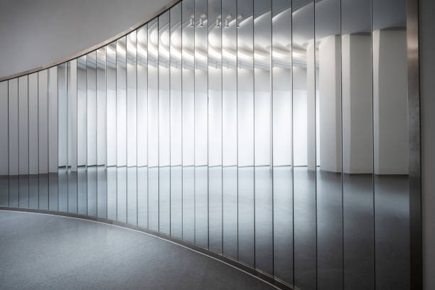 The mirrors of the bright, clean, empty interior buildings reflect