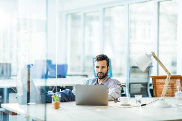 istock Businessman reading an e-mail on laptop in the office. 1364150321
