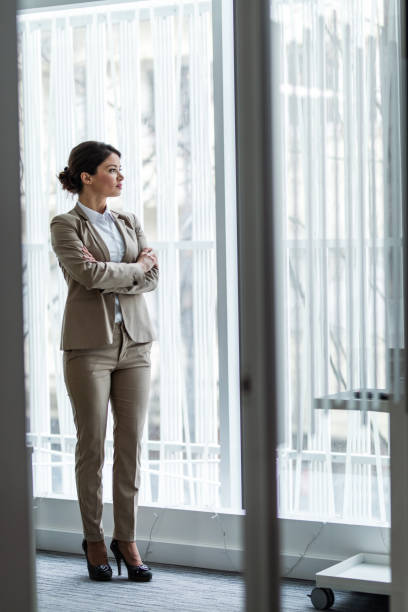 istock Pensive businesswoman looking through window. 1364150416