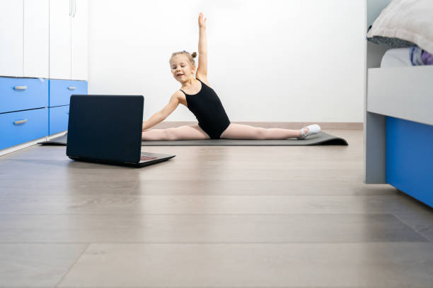 istock Little gymnast girl is training at home 1364150471