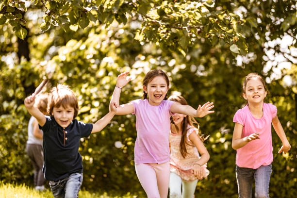 istock Carefree kids having fun while running in the park. 1364152341