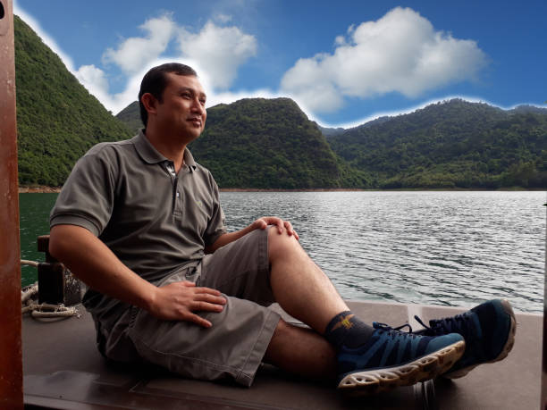 istock Handsome men sitting on the boat looking for a view. concept travle. 1364156009