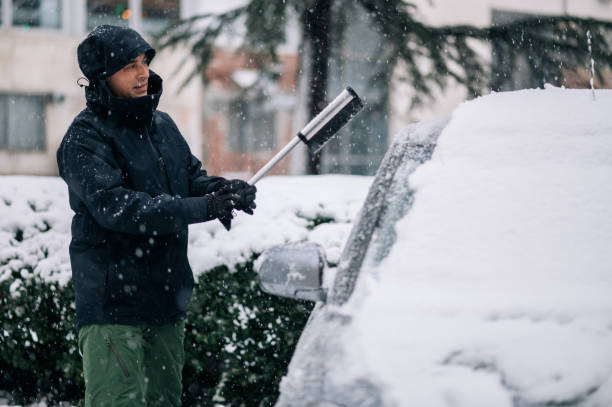 istock Middle aged man cleaning car from snow and ice 1364160453
