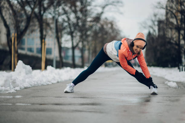 istock Woman does stretching before training in the snow in the winter. 1364160469