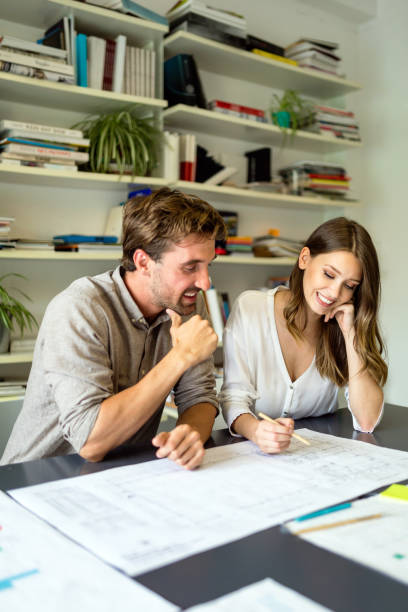 istock Group of business people on meeting with construction engineer architect looking blueprint plans 1364162973