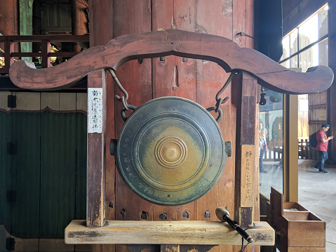 Nara, Japan - April 13, 2018: Gong and a wooden gavel at Todai-ji Temple, Nara. Todai-ji Temple is considered the largest wooden structure in the world. Tourists come to the temple.