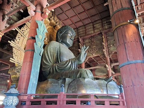 Nara, Japan - April 13, 2018: Large 15 meter Vairochanna Buddha statue at Todai-ji Temple, Nara. Todai-ji Temple is considered the largest wooden structure in the world.