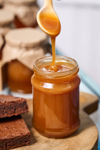 istock homemade caramel in a jar. caramel deliciously drips down a spoon into a jar 1364165132