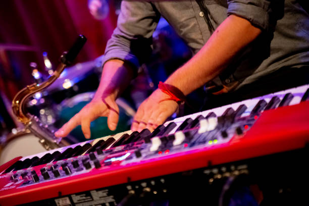 istock Pianist playing his keyboard piano on a stage for rock and roll concert 1364165341