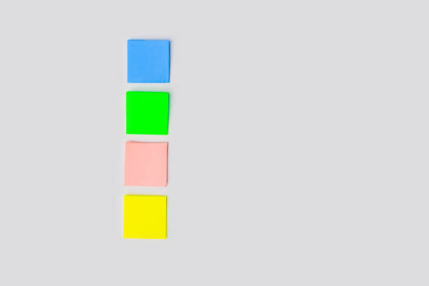 istock Four blank colorful sticky notes on gray background for entering a text. Top view and space for text. Still life, business, office supplies or education concept 1364165381