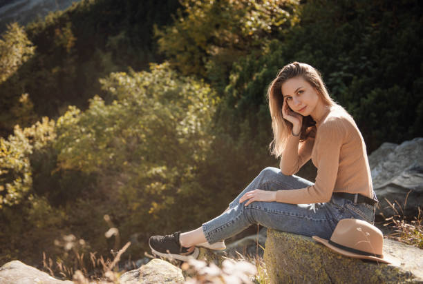 istock Young woman on a hiking trip sitting on a rock 1364166748