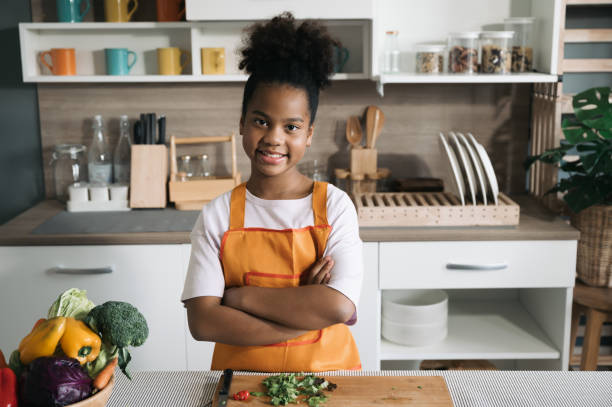 istock Happy child black skin with salad on board in kitchen 1364167963