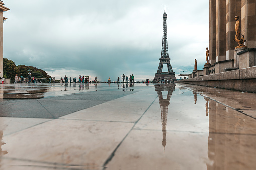 View of the Eiffel Tower in a rainy day with reflections on the Trocadero floor