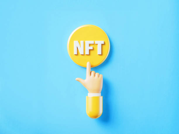 istock Cartoon Style Human Hand Clicking Over A Yellow Push Button: NFT Reads On Push Button 1364170734