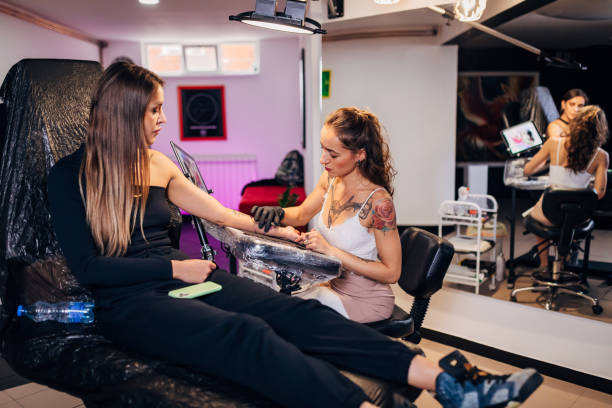 istock An experienced tattoo artist prepares her client's skin by applying moisturizer before tattooing. 1364172194