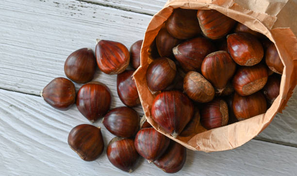 istock Chestnuts in a paper bag on a wooden background 1364176670