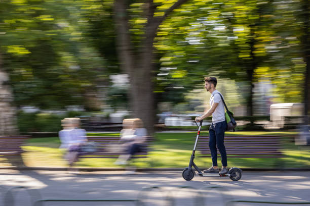 istock Man riding e-scooter in the park 1364178904