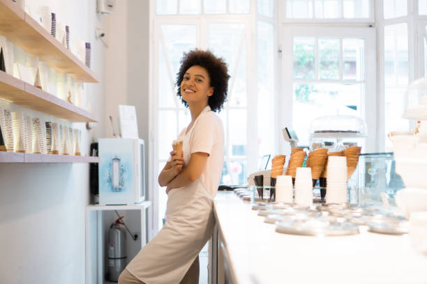istock Happy woman working at an ice cream parlor 1364180024