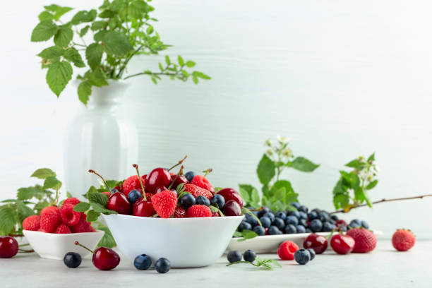istock Various fresh berries on a white wooden table. 1364180063