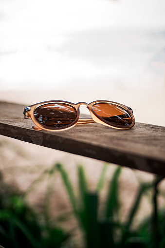 Brown glasses on a wooden board on a blur background