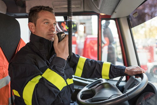 Firefighter talking through walkie-talkie with his colleagues