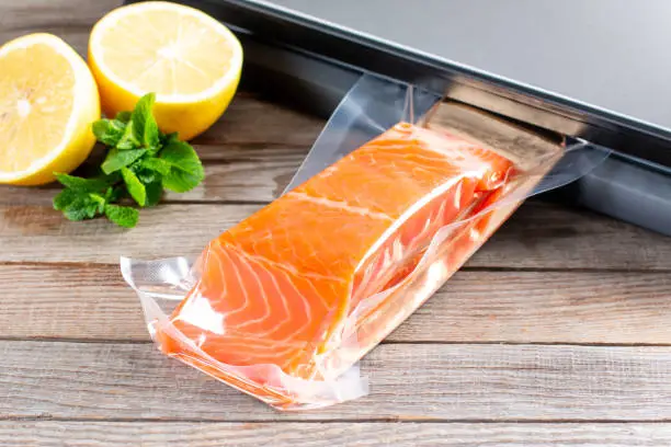 Photo of Salmon fillets in a vacuum package. Vacuumation food. Sous-vide, new technology cuisine.