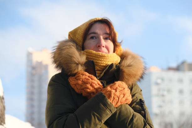istock Woman is pulling on her mittens on winter street 1364184373